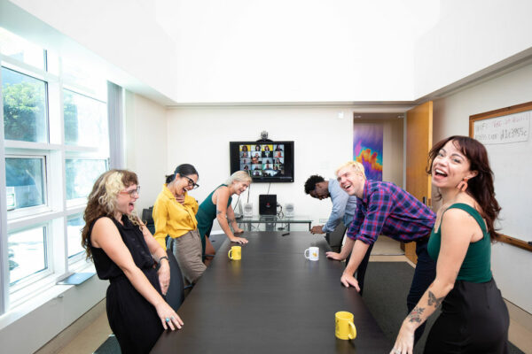 A team laughing together around a conference table
